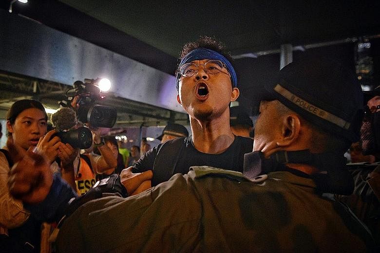 A policeman restraining a demonstrator at Harbour City in Hong Kong yesterday. Protests planned for last night included some in support of Taiwan on its National Day and rallies against perceived police brutality. ST PHOTO: CHONG JUN LIANG