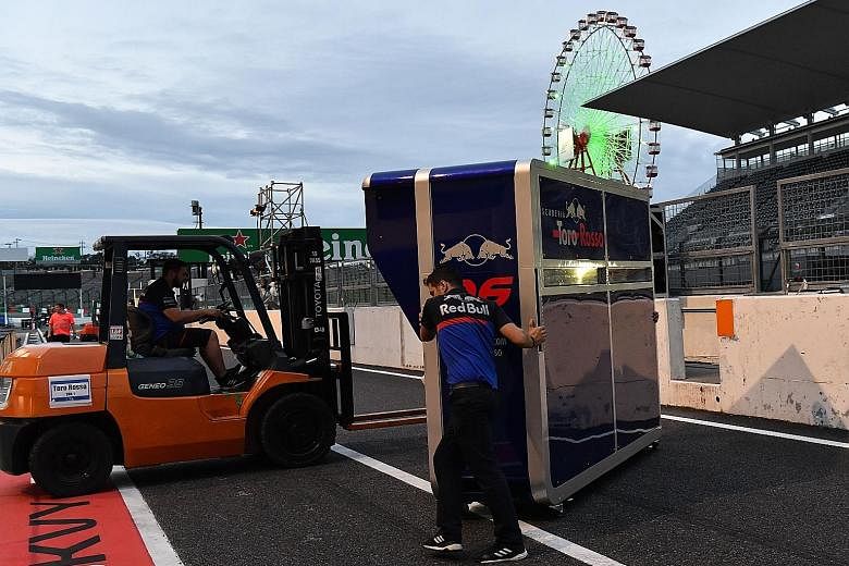 Toro Rosso mechanics removing the pit wall control desk soon after the two practice sessions for the Japanese Grand Prix at Suzuka circuit yesterday in preparation for Typhoon Hagibis' approach.