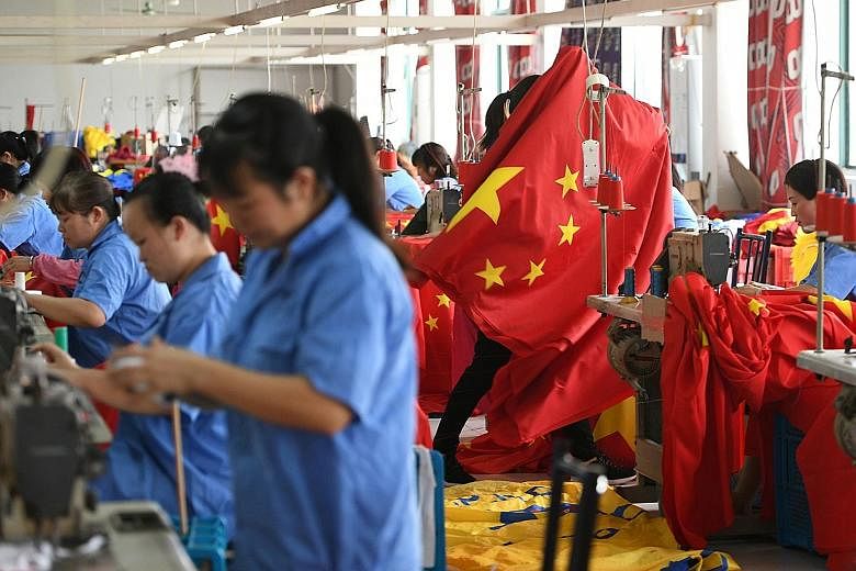 Workers making Chinese flags at a factory last month, ahead of the 70th anniversary of the founding of the People's Republic of China on Oct 1. The writer says economic growth in the country has slowed in recent quarters, raising the spectre of a lon