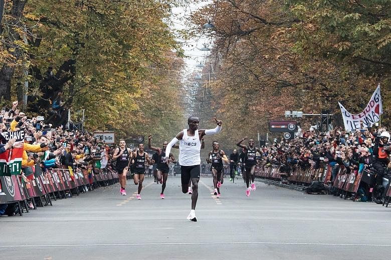 Kenya's Eliud Kipchoge waving to the crowd as he celebrates busting the mythical two-hour barrier for the marathon in Vienna yesterday - a feat that Kipchoge himself likened to a superhuman experience. PHOTO: AGENCE FRANCE-PRESSE