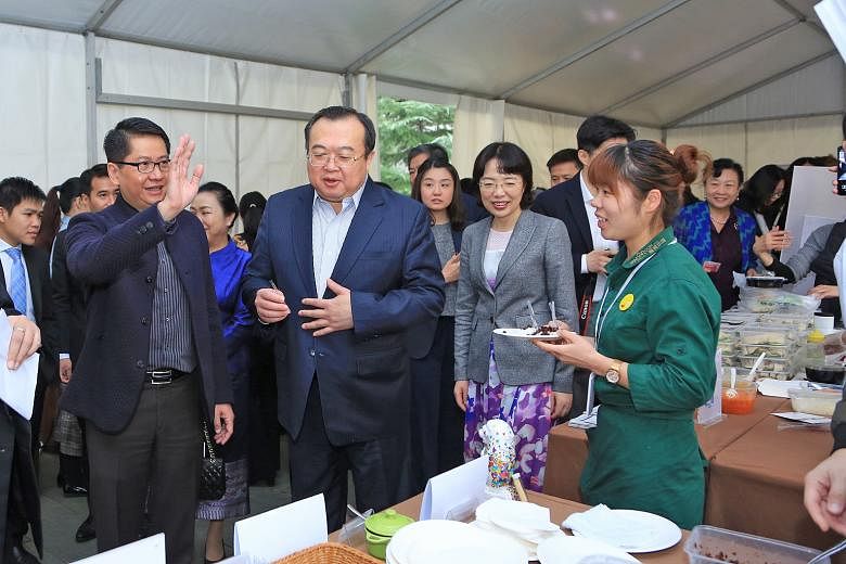 Singapore Ambassador to China Stanley Loh (in striped shirt) accompanying Deputy Director of the Central Foreign Affairs Commission Office Liu Jianchao and Chongqing Vice-Mayor Pan Yiqin (in grey jacket) at the charity bazaar held at the Singapore Em