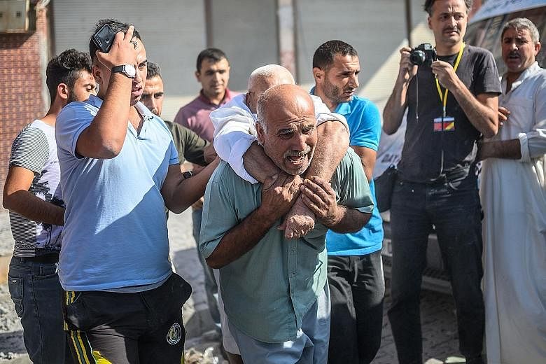 An elderly man being evacuated from a building in Akcakale, Turkey, yesterday after it was hit by a rocket reportedly fired from Syria.