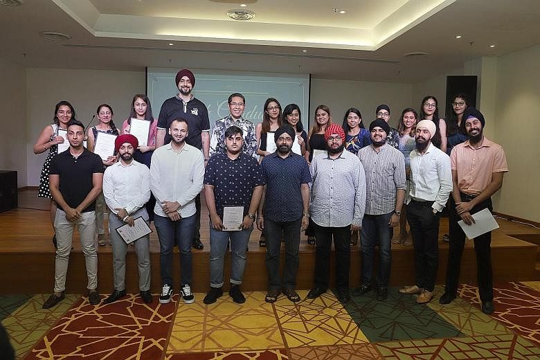Senior Minister of State for Defence and Foreign Affairs Maliki Osman (back row, centre) with Dr Ishwarpal Singh Grewal (front row, far right) and other young graduates at the annual Sikh Graduates Tea yesterday.
