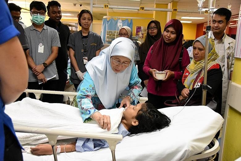 Malaysian Deputy Prime Minister Wan Azizah Wan Ismail with one of the injured at Putrajaya Hospital on Saturday. Sixteen people, including nine children, were hurt when the balloons exploded at a fitness event.