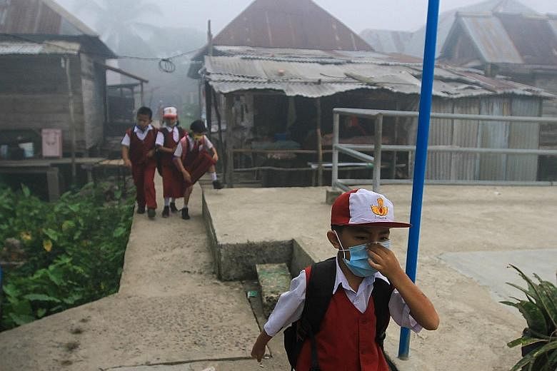 Schoolchildren donning face masks as thick haze caused by forest fires still burning across Indonesia blanketed Palembang yesterday, sending visibility plummeting to as low as 50m, and forcing most schools around the city to close. The Air Pollutant 