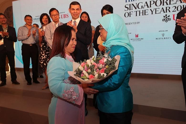 A file photo of Madam Noriza A. Mansor giving a bouquet to President Halimah Yacob at The Straits Times Singaporean of the Year award ceremony in February this year. Madam Noriza, who was there as a guest, won the inaugural ST Singaporean of the Year
