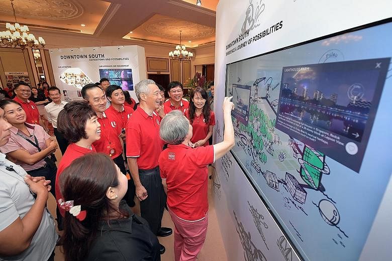 Prime Minister Lee Hsien Loong and his wife, Mrs Lee, viewing the Downtown South display with other guests at the NTUC National Delegates' Conference at Orchid Country Club yesterday.
