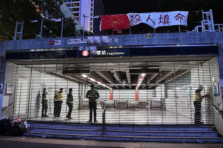 MTR staff closing the shutters at Central Station at 10pm on Monday. Hong Kong's rail system has closed early for more than a week, effectively cutting off the main mode of transportation for millions of residents. The rail operator says it needs ext