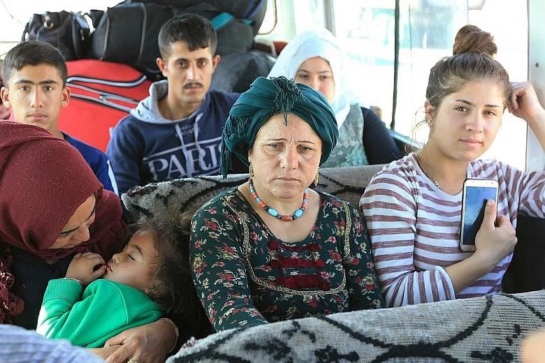 Displaced Syrian families, who fled the violence following the Turkish offensive in Syria, travelling by bus to camps on the outskirts of Dohuk city, in Iraq. The United States' decision to stand aside when Turkey advanced into Syria to push back Kur