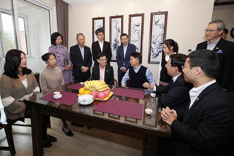 Deputy Prime Minister Heng Swee Keat visiting a family yesterday in Seasons Garden, a residential project by Keppel Land China in Tianjin Eco-city, accompanied by Mr Zhang Yuzhuo (seated, second from right), Party Secretary of the Tianjin Binhai New 