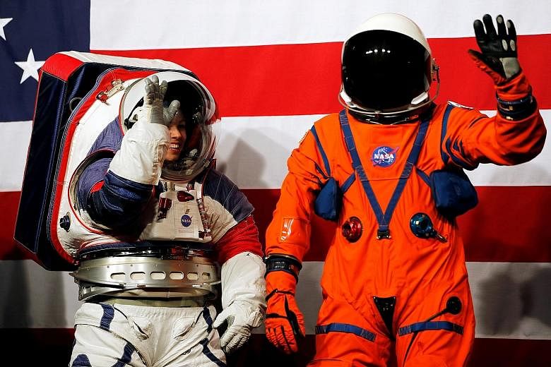 The white xEMU spacesuit and the orange Orion Crew Survival spacesuit being presented at Nasa headquarters in Washington on Tuesday.