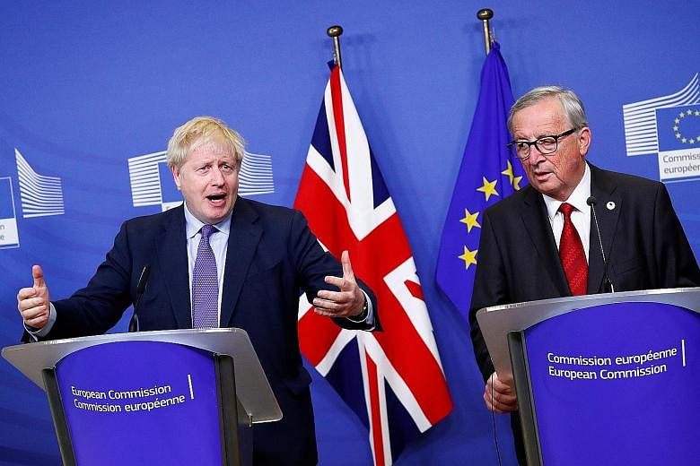 British Prime Minister Boris Johnson (left) and European Commission President Jean-Claude Juncker attending a news conference in Brussels yesterday after agreeing on the Brexit deal.