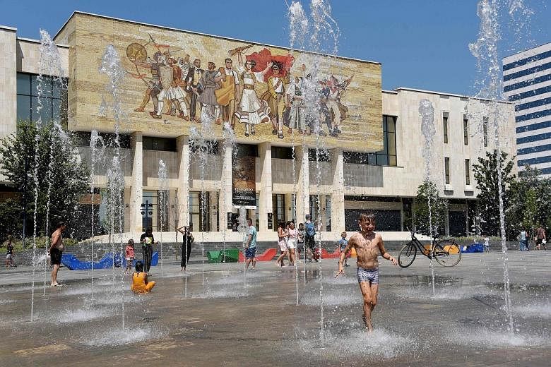 Children cooling off at the Skanderbeg Square in the Albanian capital of Tirana in August, amid a heatwave in Europe. Global warming is increasing the likelihood of more frequent and intense extreme weather events.