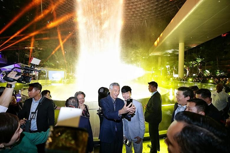 Prime Minister Lee Hsien Loong taking a wefie with local Mandopop star JJ Lin during a light and sound show at the official opening of Jewel Changi Airport yesterday. With them was Mrs Lee (left). ST PHOTO: KEVIN LIM