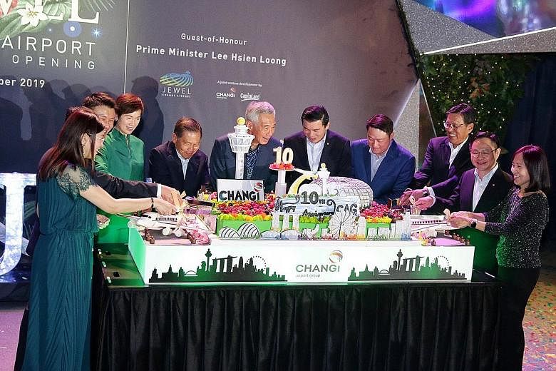 Prime Minister Lee Hsien Loong cutting a cake yesterday to celebrate Changi Airport Group's 10th anniversary with (from left) CAG's executive vice-president of commercial Lim Peck Hoon; CAG's executive vice-president of airport management Tan Lye Tec