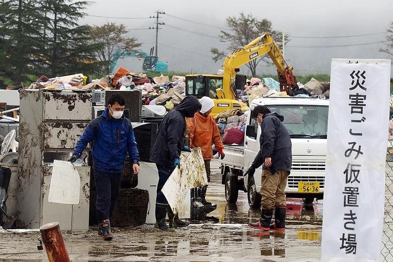 Marumori residents cleaning up a house that was affected by flooding caused by Typhoon Hagibis last Monday. PHOTO: REUTERS Residents and volunteers at the trash collection point in Marumori town in Miyagi prefecture yesterday, a week after Typhoon Ha
