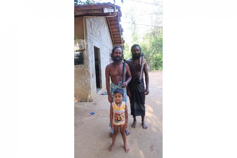 Sudhawaninila (centre), chief of the local Vedda tribe, with his second in command Poromala and his granddaughter.