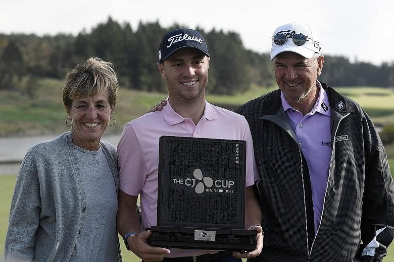Justin Thomas of the United States, with mother Jani and father Mike after winning the CJ Cup in Jeju Island yesterday. His parents had flew over from Louisville to watch him play in the tournament.