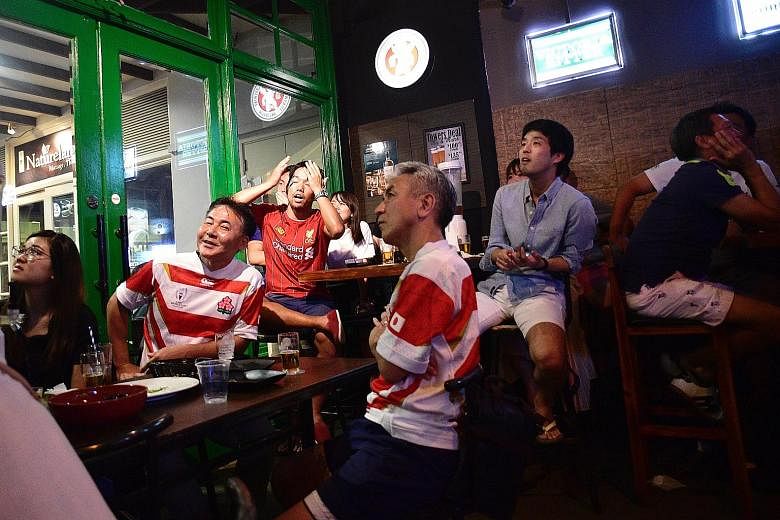 Japanese fans at Thunderbird Bistro in Robertson Walk watching yesterday's World Cup quarter-final game. One supporter said: "We are disappointed but not sad because we are among the best eight teams."