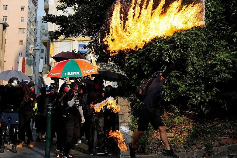 An anti-government protester throwing a petrol bomb towards the Tsim Sha Tsui police station during a protest in Hong Kong yesterday. PHOTO: REUTERS