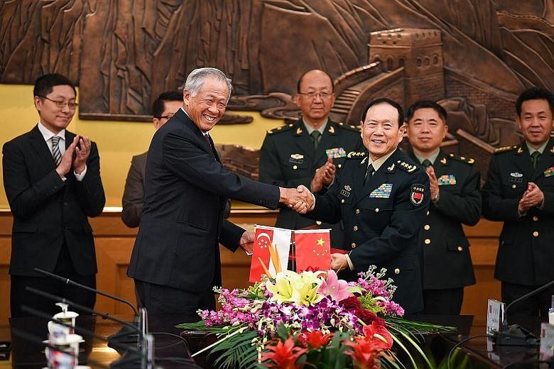 Defence Minister Ng Eng Hen and his Chinese counterpart Wei Fenghe (right) after the signing of the enhanced defence pact yesterday in Beijing. PHOTO: MINDEF