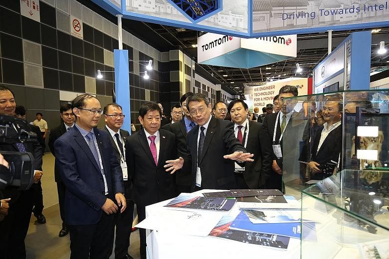 Coordinating Minister for Infrastructure and Minister for Transport Khaw Boon Wan (front, second from left) touring the Intelligent Transport Systems World Congress' exhibition yesterday at the Suntec Singapore Convention and Exhibition Centre. ST PH