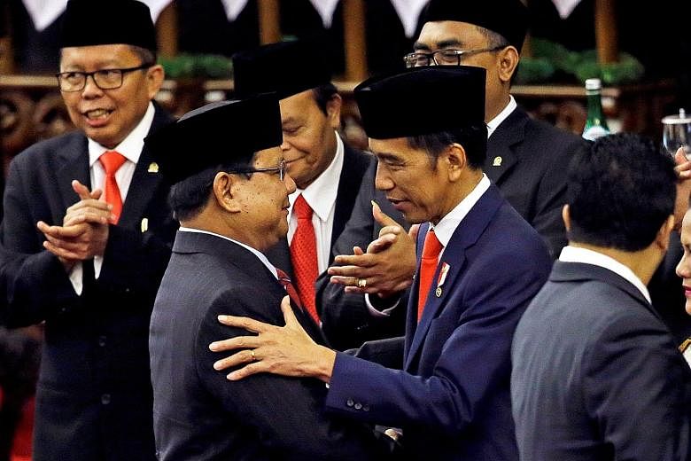 Indonesian President Joko Widodo being congratulated by Mr Prabowo Subianto, leader of opposition party Gerindra, after his inauguration in Jakarta on Sunday. Some volunteers from Mr Joko's youth volunteer group were disappointed with the decision fo