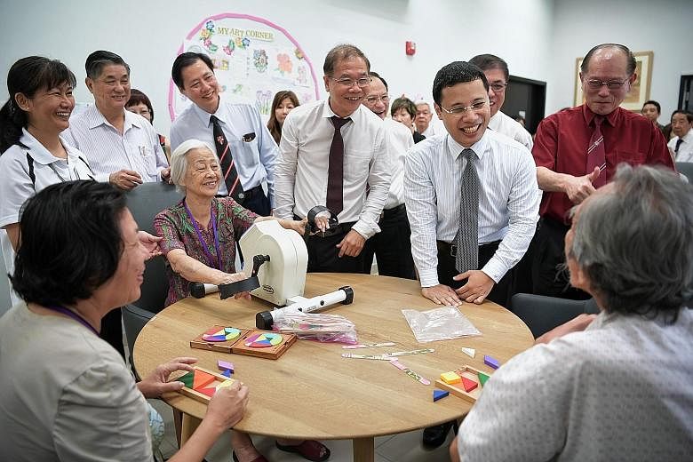 Social and Family Development Minister Desmond Lee (standing, second from right) speaking to seniors at St John Singapore Dementia Centre yesterday, when the centre was officially launched.