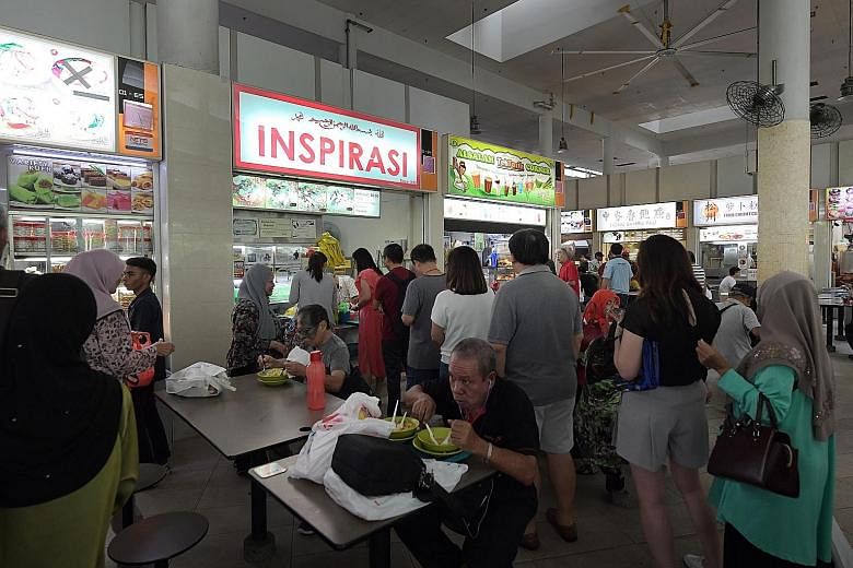 Left: The Bedok Interchange Hawker Centre, which is managed by NTUC Foodfare. Right: Mr Seah (centre) topping up his Kopitiam card at the Kopitiam in Bedok North Street 1. With him are Mr Alden Tan (left), FairPrice Group's CEO of food services, and 