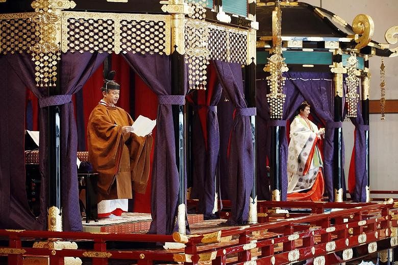 Japan's Emperor Naruhito proclaiming his enthronement from the platform of the Takamikura throne yesterday. His wife, Empress Masako, took the slightly shorter Michodai platform. PHOTO: EPA-EFE President Halimah Yacob and Iceland's President Gudni Th
