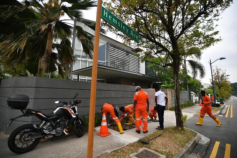 Workers clearing the drains in Serangoon Gardens last month as part of the efforts to fight dengue. Singapore saw a 13-week downward trend in the number of reported dengue cases until the week ending Oct 12, but the NEA urged continued vigilance due 