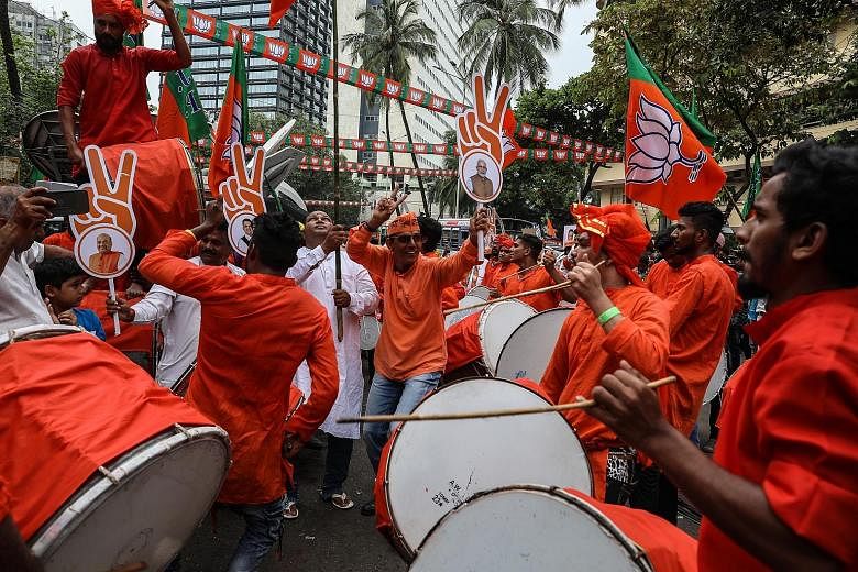 Supporters of India's ruling BJP celebrating their lead in the Maharashtra legislative election outside the party's head office in Mumbai yesterday.