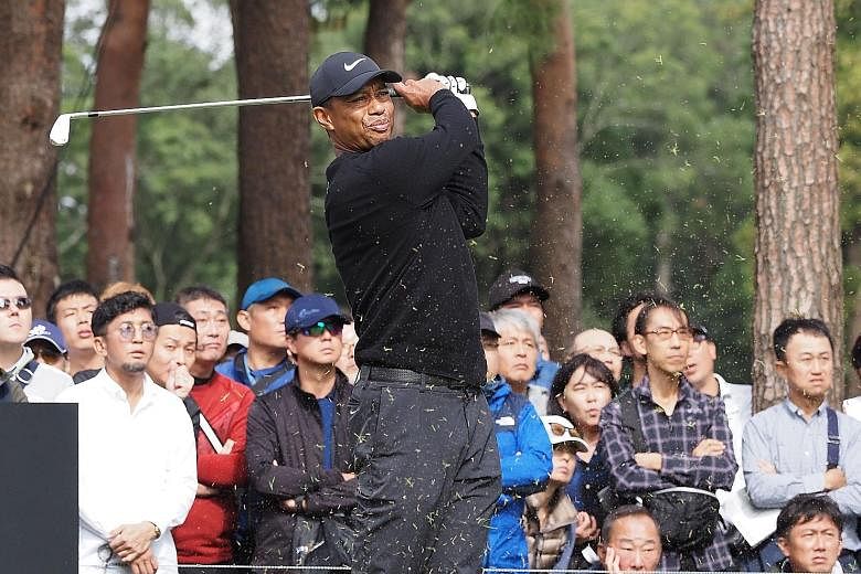 Tiger Woods teeing off at the second hole in the first round of the Zozo Championship yesterday, with huge crowds trailing after him at the Narashino Country Club course. PHOTO: AGENCE FRANCE-PRESSE