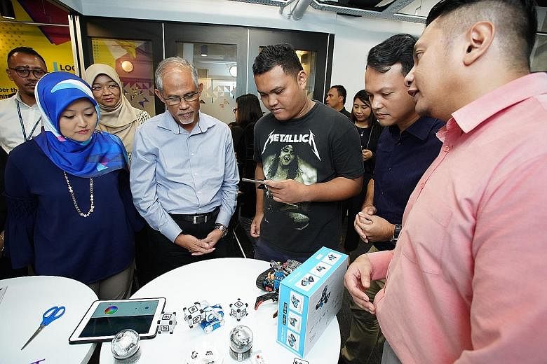 Minister-in-charge of Muslim Affairs and Mendaki chairman Masagos Zulkifli at a robotics booth at the launch of the satellite centre in Jurong yesterday. With him are (from left) MP for Jurong GRC Rahayu Mahzam, ITE College West student Zulkarnaien S. Idr