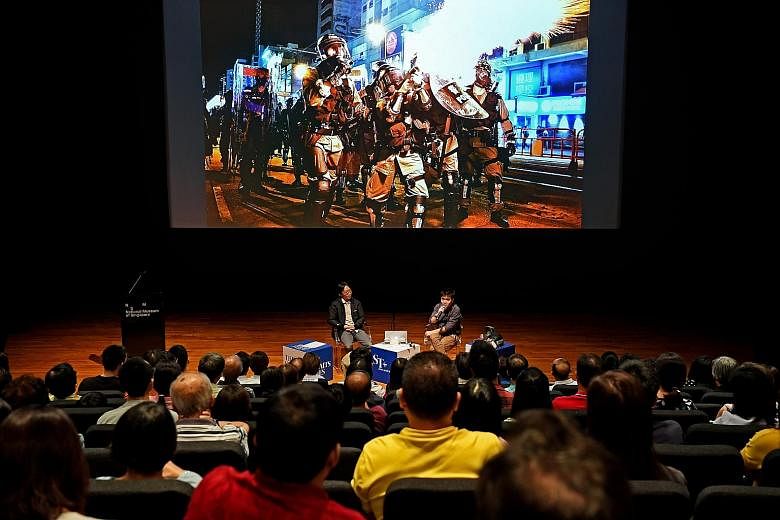 Straits Times photojournalists Lim Yaohui (left) and Chong Jun Liang giving a talk yesterday on their experience covering the political unrest in Hong Kong, at the National Museum of Singapore, as part of the Through The Lens photo exhibition organis