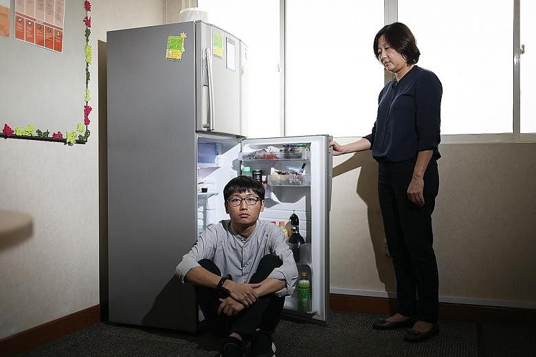 Mr Wayne Kee's (far left) OCD made him carry out repetitive tasks like opening and closing the refrigerator door for hours. When he got tired, he would ask his mother, Ms Evelyn Chng (left), to take over. OCD sufferer Vera rewrote her school notes re