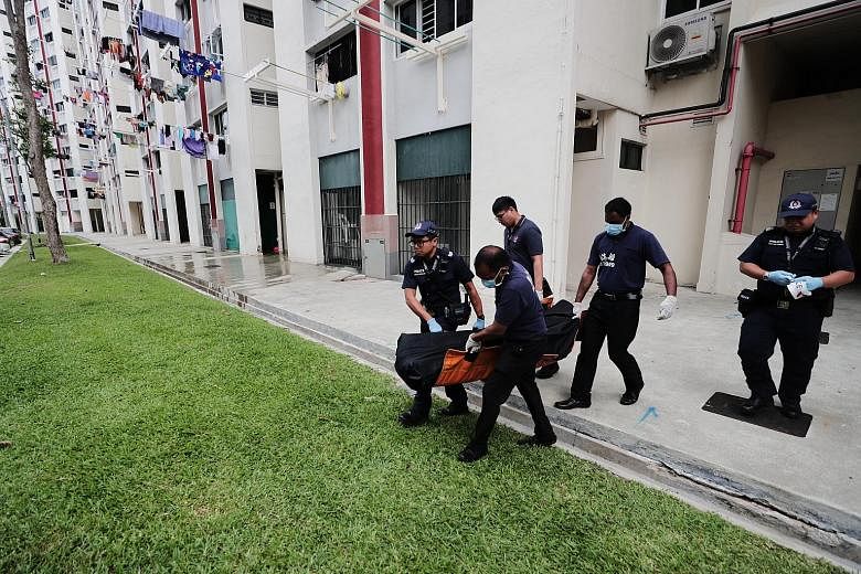 Police officers and undertakers removing the body of a man who was found dead in a unit at Block 633 Ang Mo Kio Avenue 6 yesterday morning. A 54-year-old woman is expected to be charged with his murder today. Preliminary investigations showed that th