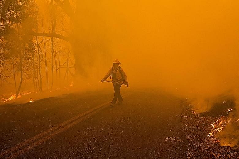 A firefighter emerging from a cloud of smoke while battling the Kincade fire in Healdsburg, California, on Sunday.