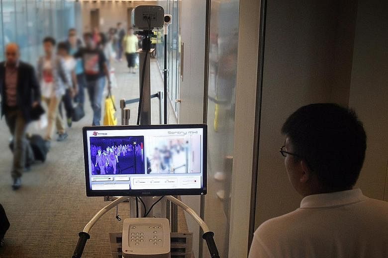 Passengers arriving at Changi Airport from Qatar in 2014 having their temperatures screened by a thermal scanner as a precaution against the spread of the Middle East respiratory syndrome.