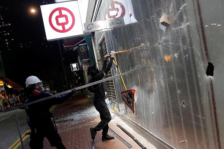 Protesters vandalising a branch of Bank of China in Tsuen Wan, Hong Kong, this month. A stress test done by JPMorgan projected that the city's lenders could see earnings fall 24 per cent to 45 per cent next year and 39 per cent to 67 per cent in 2021