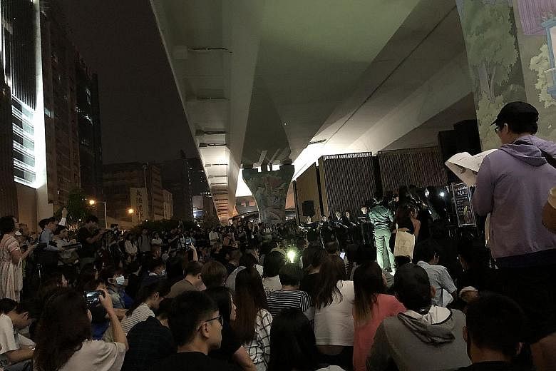 Above: Protesters folding paper cranes at a Sha Tin mall to form the words "Free HK" this month. The event was one of many community activities to maintain the momentum of the protest movement. Below: Hundreds gathering under a flyover in Kwun Tong o