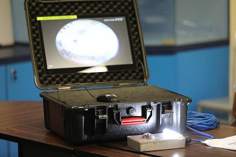 The Portable Under-Vehicle Surveillance System (left) uses a camera with a fish-eye lens embedded in a speed bump. Camera footage is shown on a 17-inch screen (above) in a briefcase that is resistant to all types of weather.