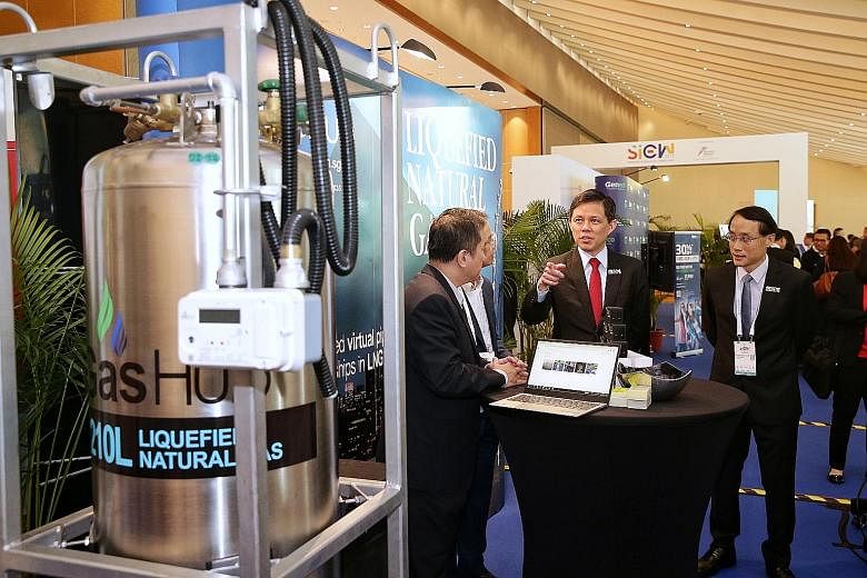 Minister for Trade and Industry Chan Chun Sing at a booth showing the model of a canister used for rebottling liquefied natural gas on Jurong Island yesterday. The model was on display at the Sands Expo and Convention Centre for the Singapore Interna