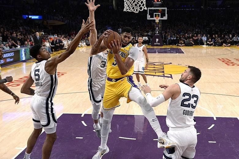 The Lakers' Anthony Davis pulling down a rebound against Grizzlies players (from left) Bruno Caboclo, Grayson Allen and Marko Guduric at the Staples Centre on Tuesday. The hosts won 120-91.