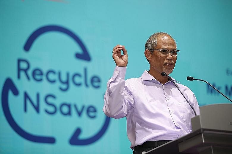 Members of the public using the "reverse" vending machines at the launch of the Recycle N Save initiative at Our Tampines Hub yesterday. For every four drink receptacles deposited, a discount voucher worth 20 cents that can be used at any FairPrice, 