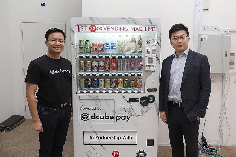 D'Cube Concepts founder Daniel Koh (above left) and Fomo Pay co-founder Louis Liu with one of the vending machines on trial that lets consumers use their cellphones to make payment via national QR code SGQR, which consolidates over 20 e-payment schem