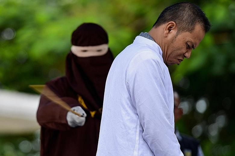 Aceh Ulema Council member Mukhlis being whipped last Thursday, for having an affair with a married woman.