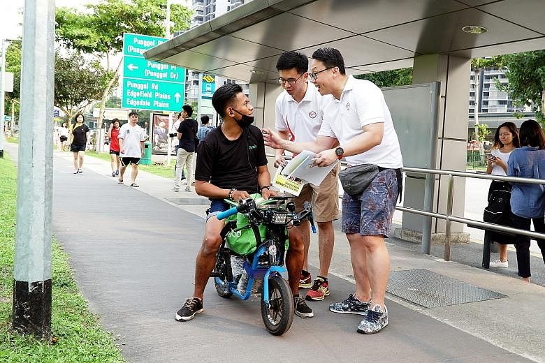 Coraltree Residents Network chairman Andy Ho (centre) and Parc Terraces Residents Network chairman John Yap talking to a personal mobility device user in Punggol about using the device safely and responsibly, as part of the Active Mobility Patrol sch