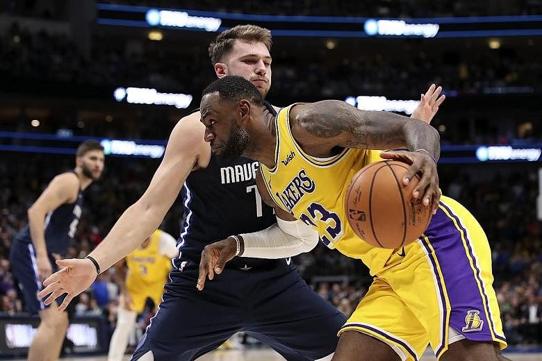 Los Angeles Lakers' LeBron James finding the Dallas Mavericks' Luka Doncic a tough obstacle to get past in the overtime period. The Lakers won 119-110. 