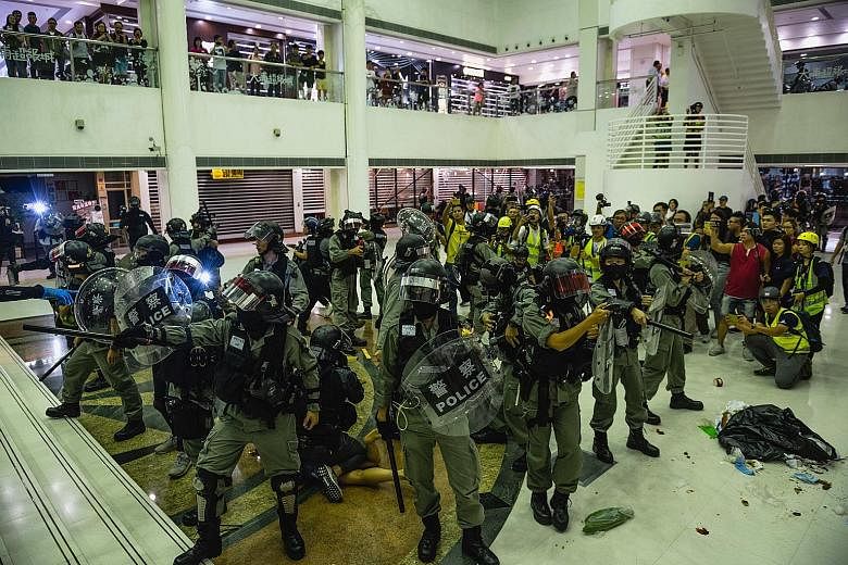 Riot police inside a shopping mall in Hong Kong during clashes with anti-government protesters last Sunday. Twelve police officers were also injured during the weekend clashes, with more than 300 people ranging from 14 to 54 years of age arrested bet